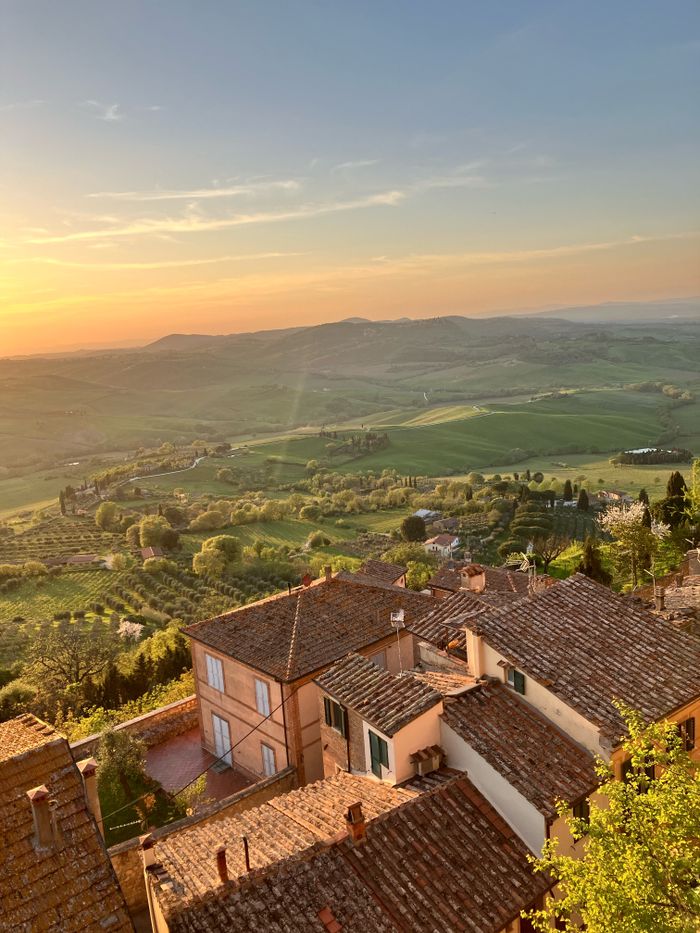 Services Stunning sunset view of Tuscan rooftops and lush countryside landscape.